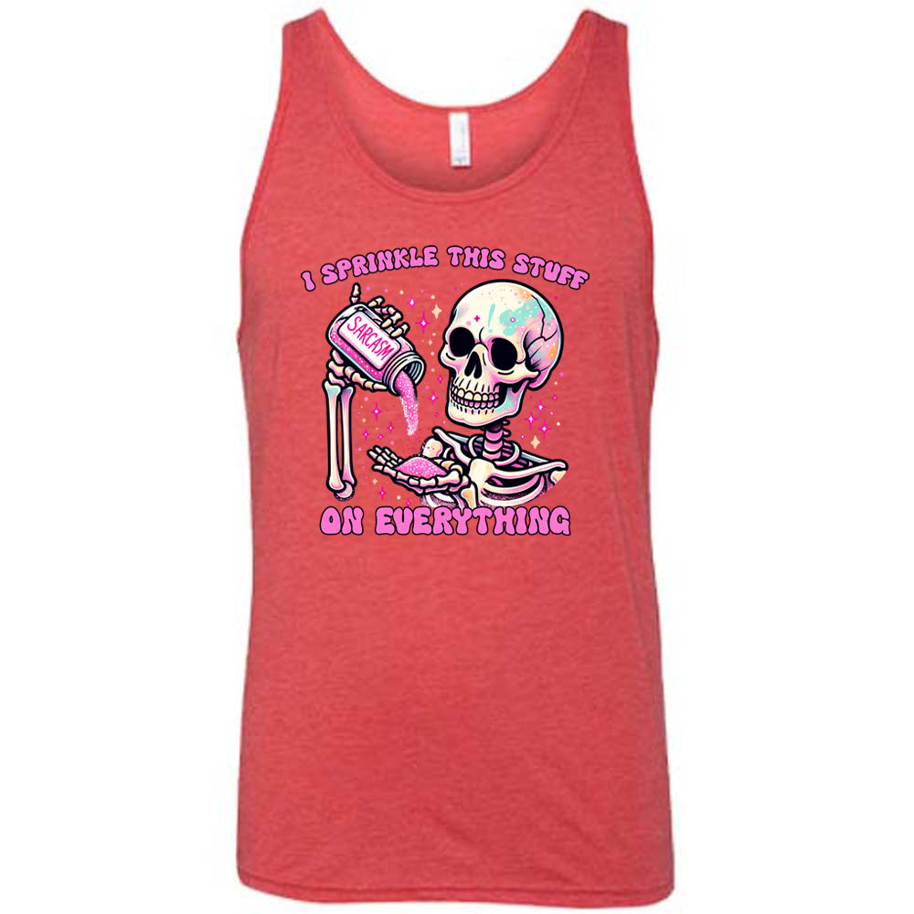red unisex tank with the words "I sprinkle this stuff on everything" on it, and the graphic of a skeleton who is pouring a jar labeled "sarcasm" filled with pink glittery material into its hand, surrounded by little pink and white stars
