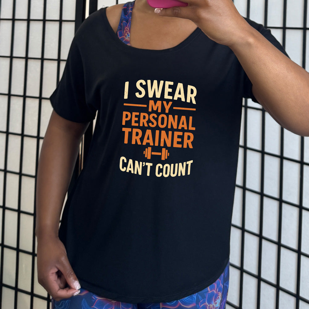 black slouchy tee with the words "I swear my personal trainer can't count" on it, and the small image of a barbell