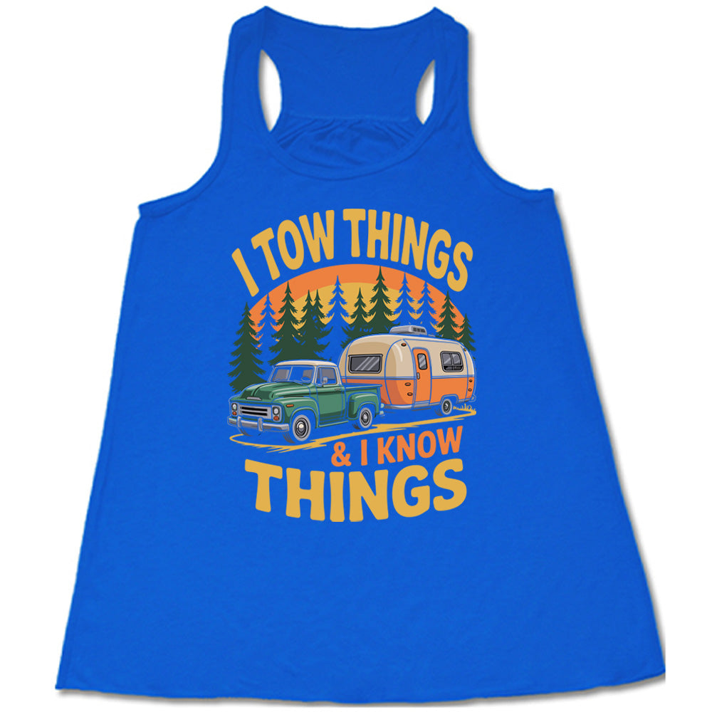 blue flowy tank with the words "I tow things & I know thing" on it, with the graphic of an old-fashioned truck pulling a camper on a road lined with tall trees