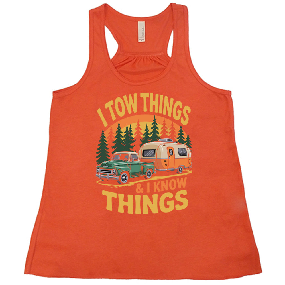 coral flowy tank with the words "I tow things & I know thing" on it, with the graphic of an old-fashioned truck pulling a camper on a road lined with tall trees