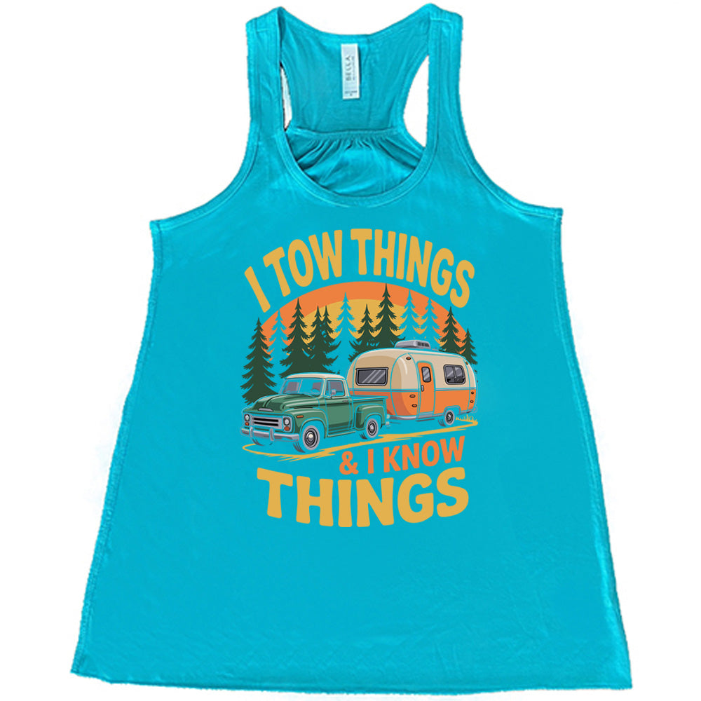 teal flowy tank with the words "I tow things & I know thing" on it, with the graphic of an old-fashioned truck pulling a camper on a road lined with tall trees