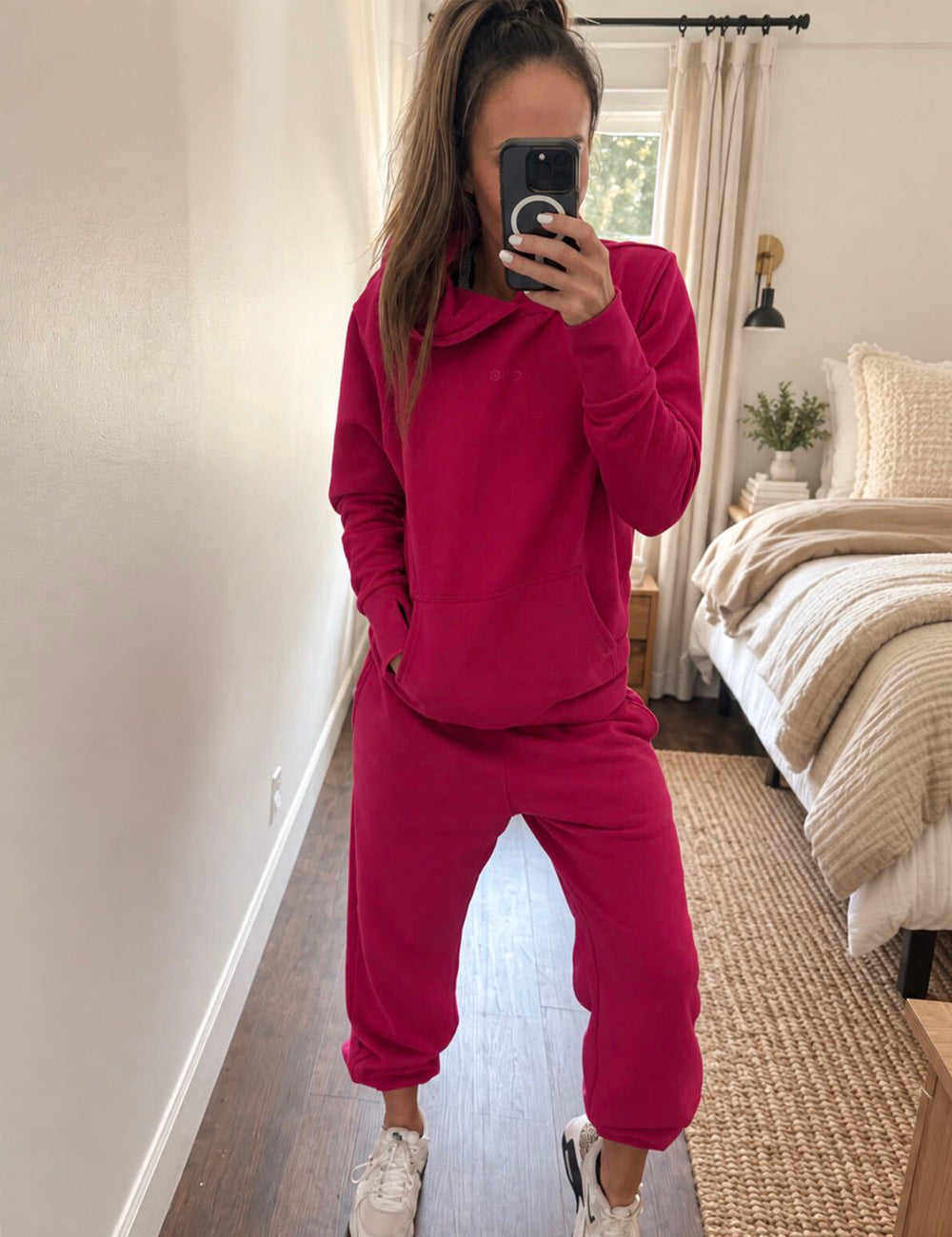 mirror selfie of a model wearing a pink sweatshirt and matching sweatpants