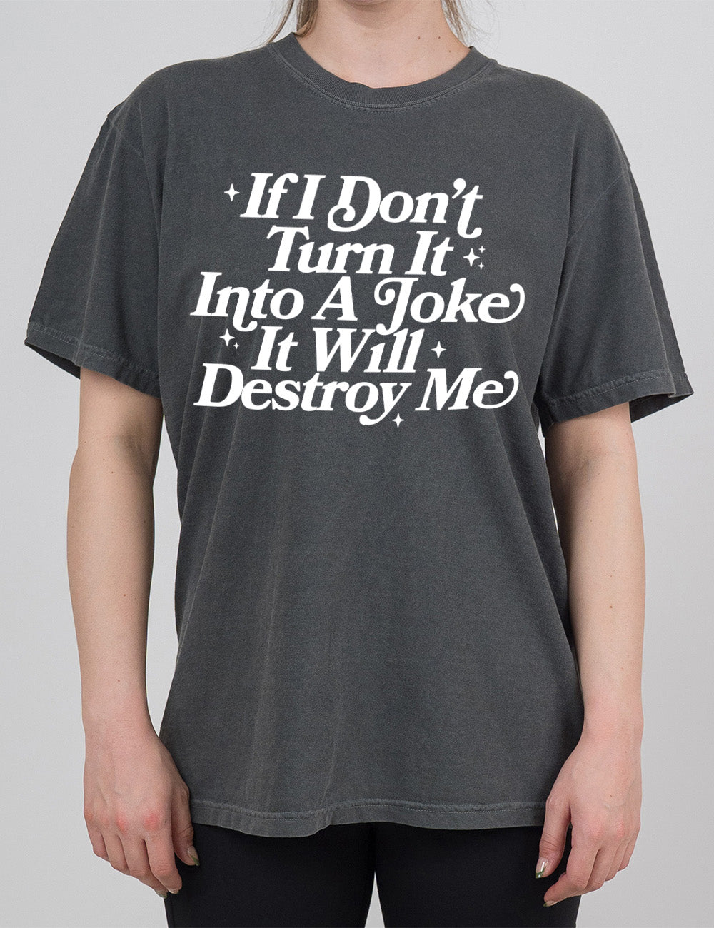 pepper modern tee with words on it saying "If I don't turn it into a joke it will destroy me", embellished by little star graphics