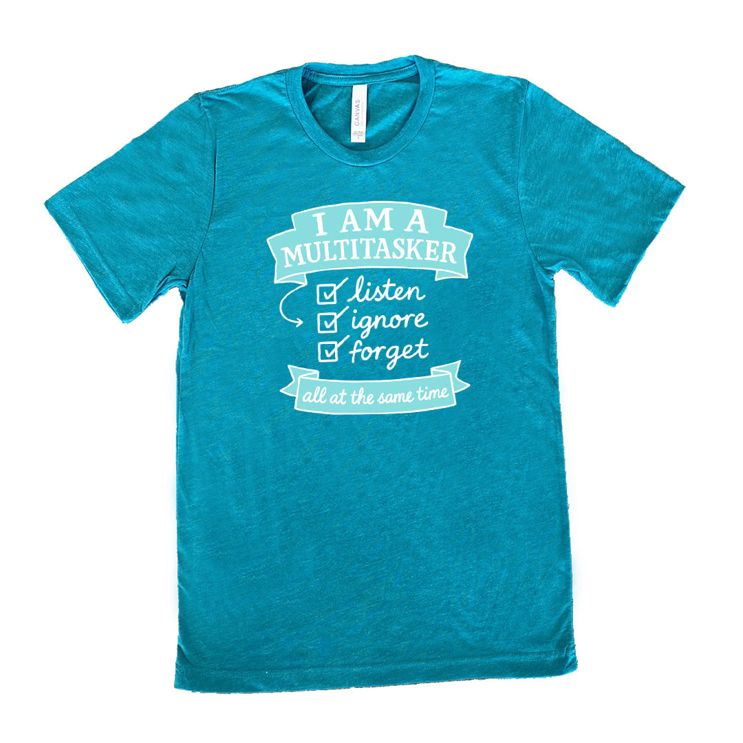 Teal Unisex Tee, with wording I am a Multitasker listen ignore forget all at the same time, checkmarks, an arrow, and banners