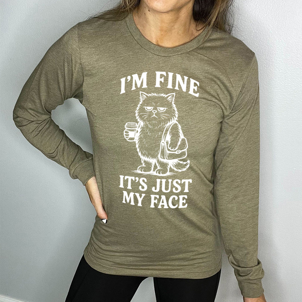 heather olive long sleeve shirt with the words "I'm fine it's just my face" on it, around the graphic of a cat with a resting-grumpy face, holding a coffee and wearing a purse