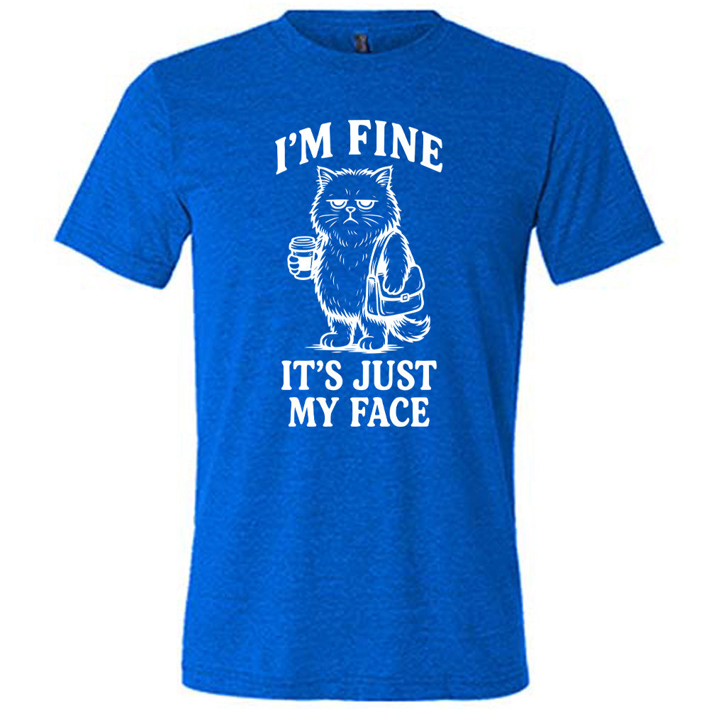 blue unisex tee with the words "I'm fine it's just my face" on it, around the graphic of a cat with a resting-grumpy face, holding a coffee and wearing a purse