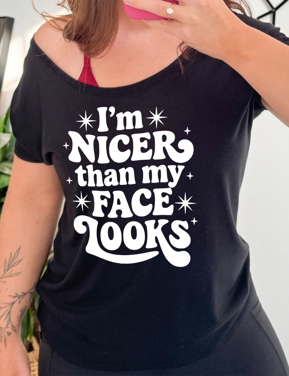 black slouchy tee with the words "I'm nicer than my face looks" surrounded by stars