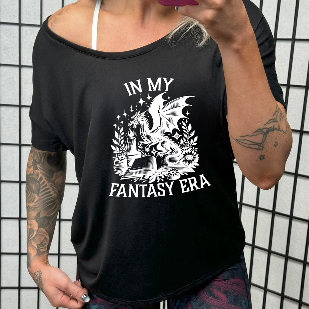 shirt with a dragon lighting a candle over a book graphic on it that says "In My Fantasy Era"