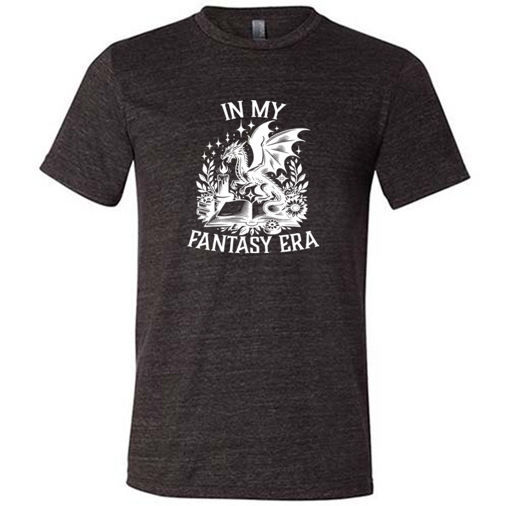 Black colored shirt with a dragon lighting a candle over a book graphic on it that says "In My Fantasy Era"