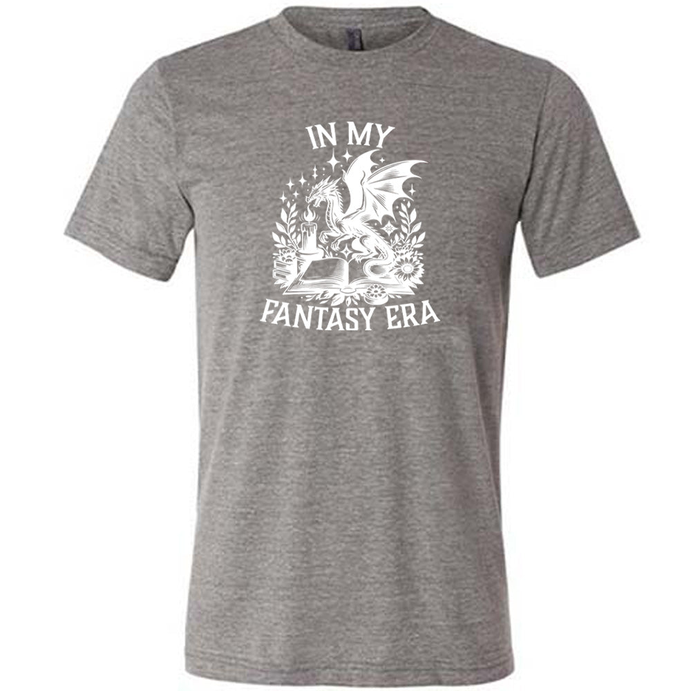 Grey colored shirt with a dragon lighting a candle over a book graphic on it that says "In My Fantasy Era"