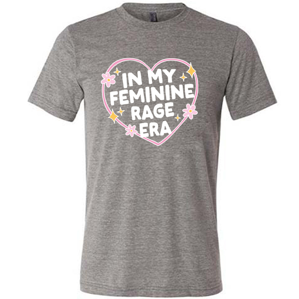 grey unisex tee with the words "in my feminine rage era" within a heart, with scattered flowers and stars