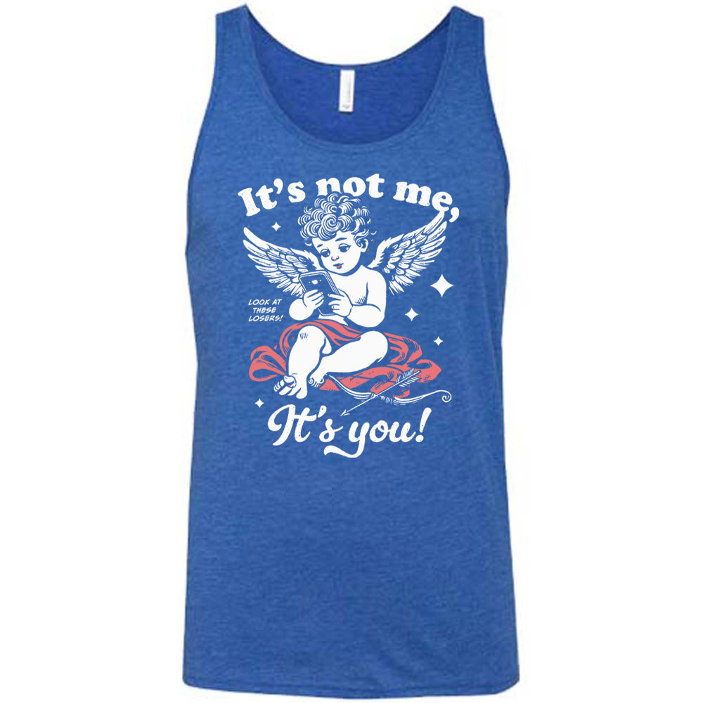 blue unisex tank with the words "it's not me, it's you!" on it, with graphics of Cupid looking at a cell phone (presumably looking at dating apps), with small words saying "look at these losers!" and Cupid's bow and arrow at his side