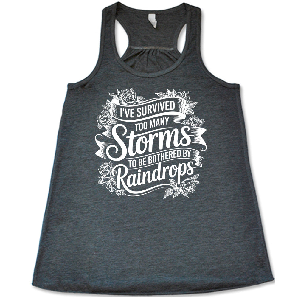 Grey Flowy Tank, with wording I've Survived Too Many Storms to be Bothered by Raindrops, banners and flowers