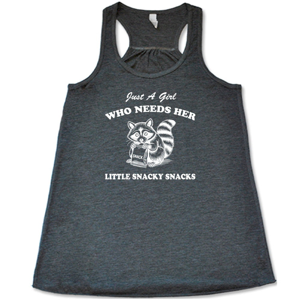 Grey colored flowy tank with a raccoon holding a snack graphic on it that says "Just a Girl Who Needs Her Little Snacky Snacks"