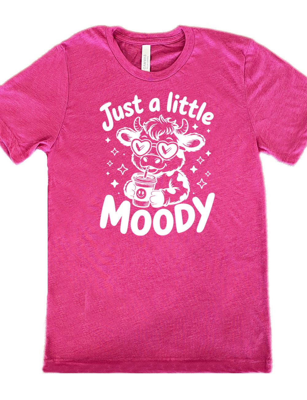 berry unisex tee with the graphic of a cartoon cow, wearing heart sunglasses and drinking out of an iced cup with a straw, surrounded by little stars, as well as the words "just a little moody" around it