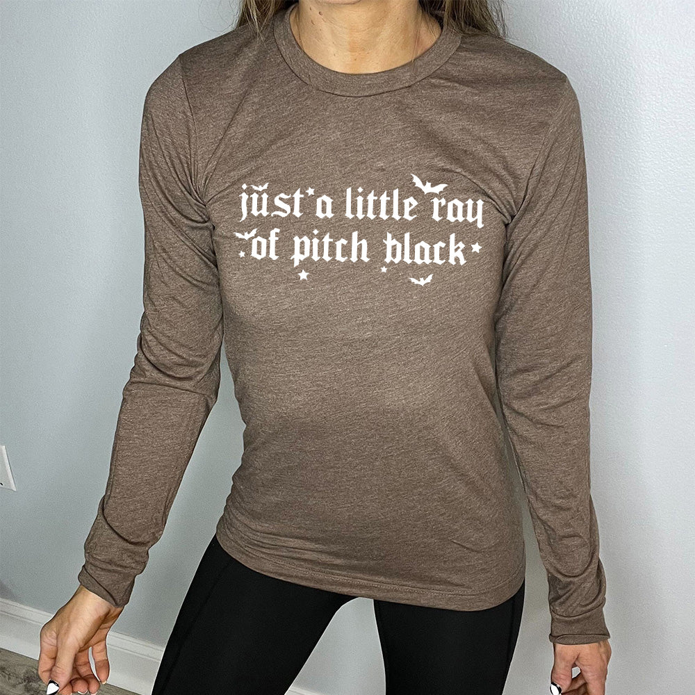heather brown long sleeve shirt with the words "just a little ray of pitch black" on it in a medieval font, with little bats and stars accenting the words