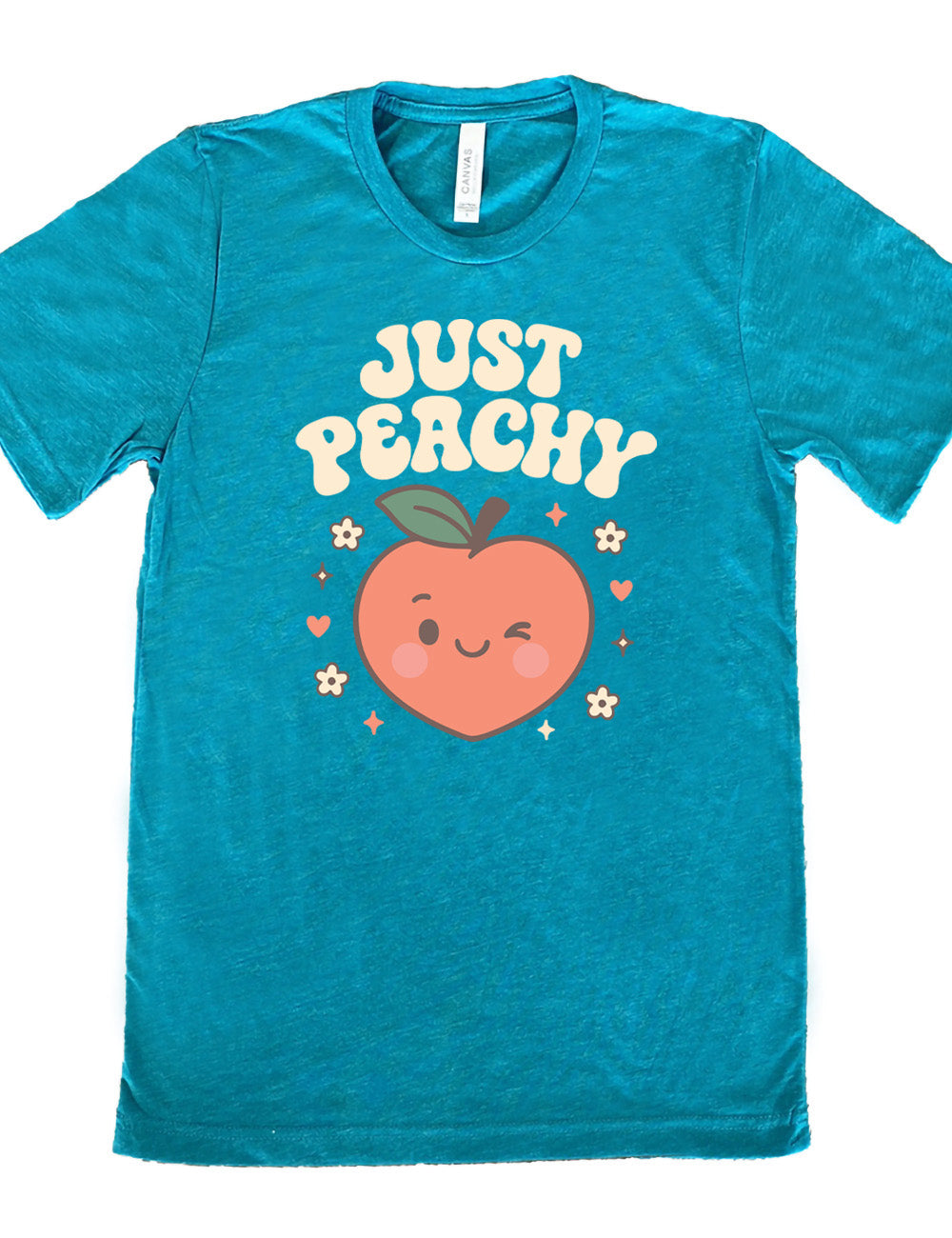 teal unisex tee with the graphic of a winking peach, surrounded by little hearts, flowers, and stars, with the words above it saying "just peachy"