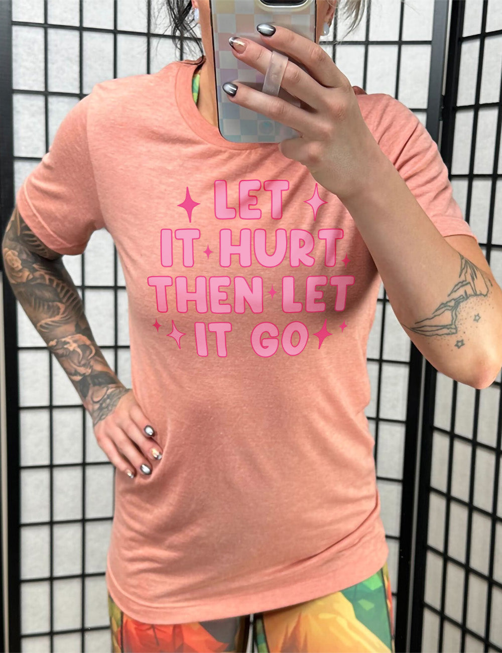 sunset unisex tee with wording saying "let it hurt then let it go" with star graphics embellishing