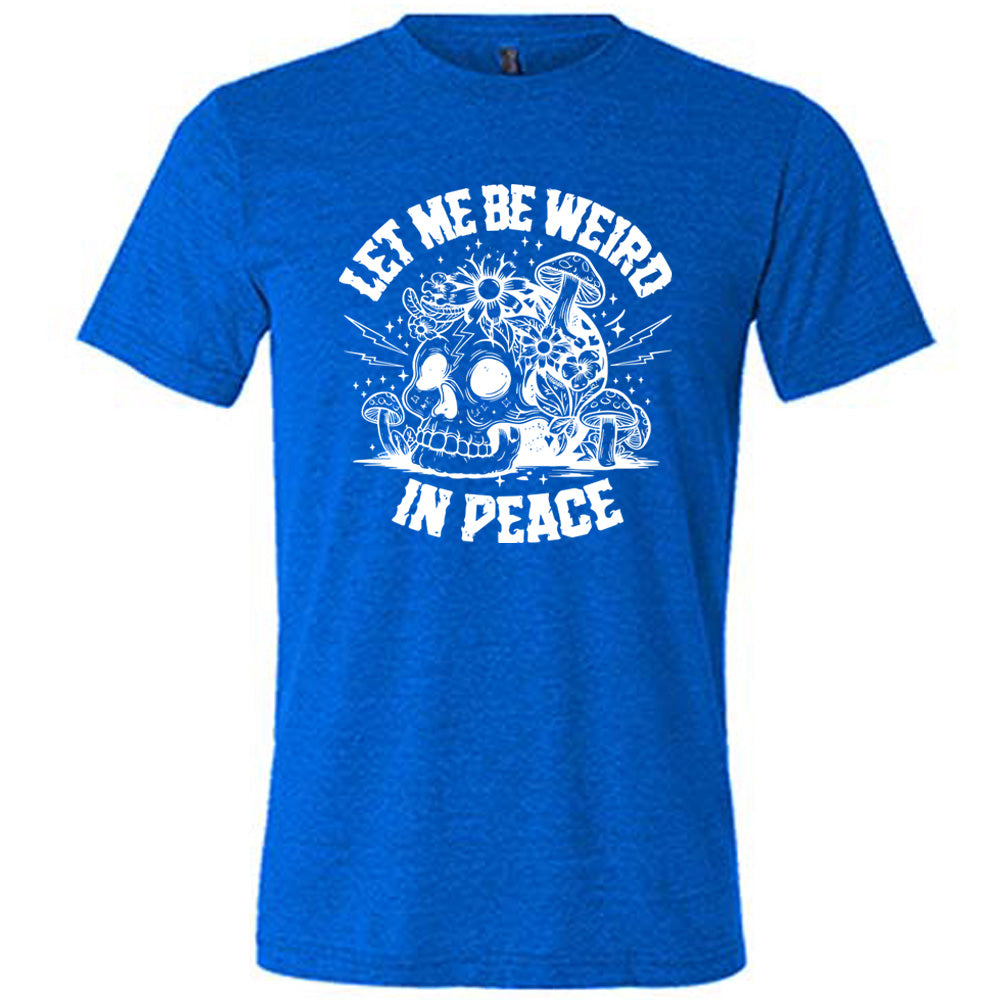 blue unisex tee with the words "let me be weird in peace" on it with the graphic of a skull on the ground with mushrooms growing on and around it, as well as flowers growing on it, surrounded by little stars and lightening bolts