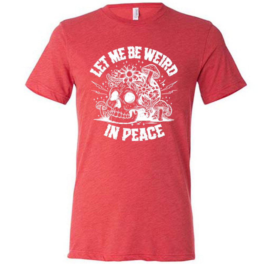 red unisex tee with the words "let me be weird in peace" on it with the graphic of a skull on the ground with mushrooms growing on and around it, as well as flowers growing on it, surrounded by little stars and lightening bolts