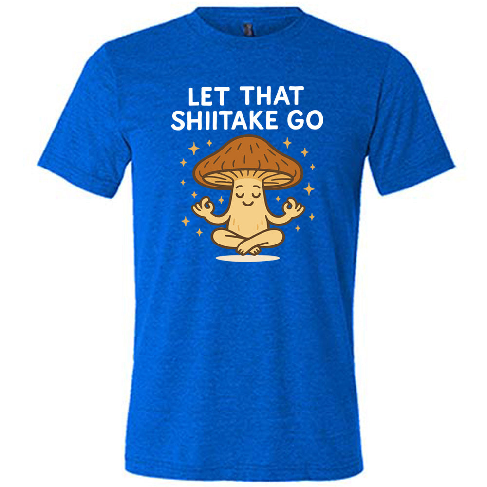 blue unisex tee with the words "let that shiitake go" on it and the graphic of a mushroom doing a yoga pose, surrounded by little stars