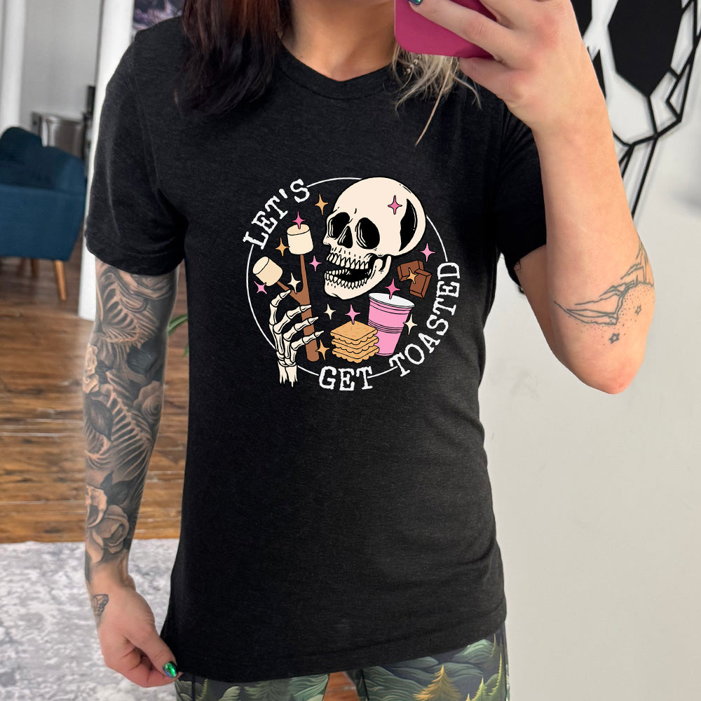 Black colored shirt with a skull and marshmallow stick graphic on it that says "Let's Get Toasted"