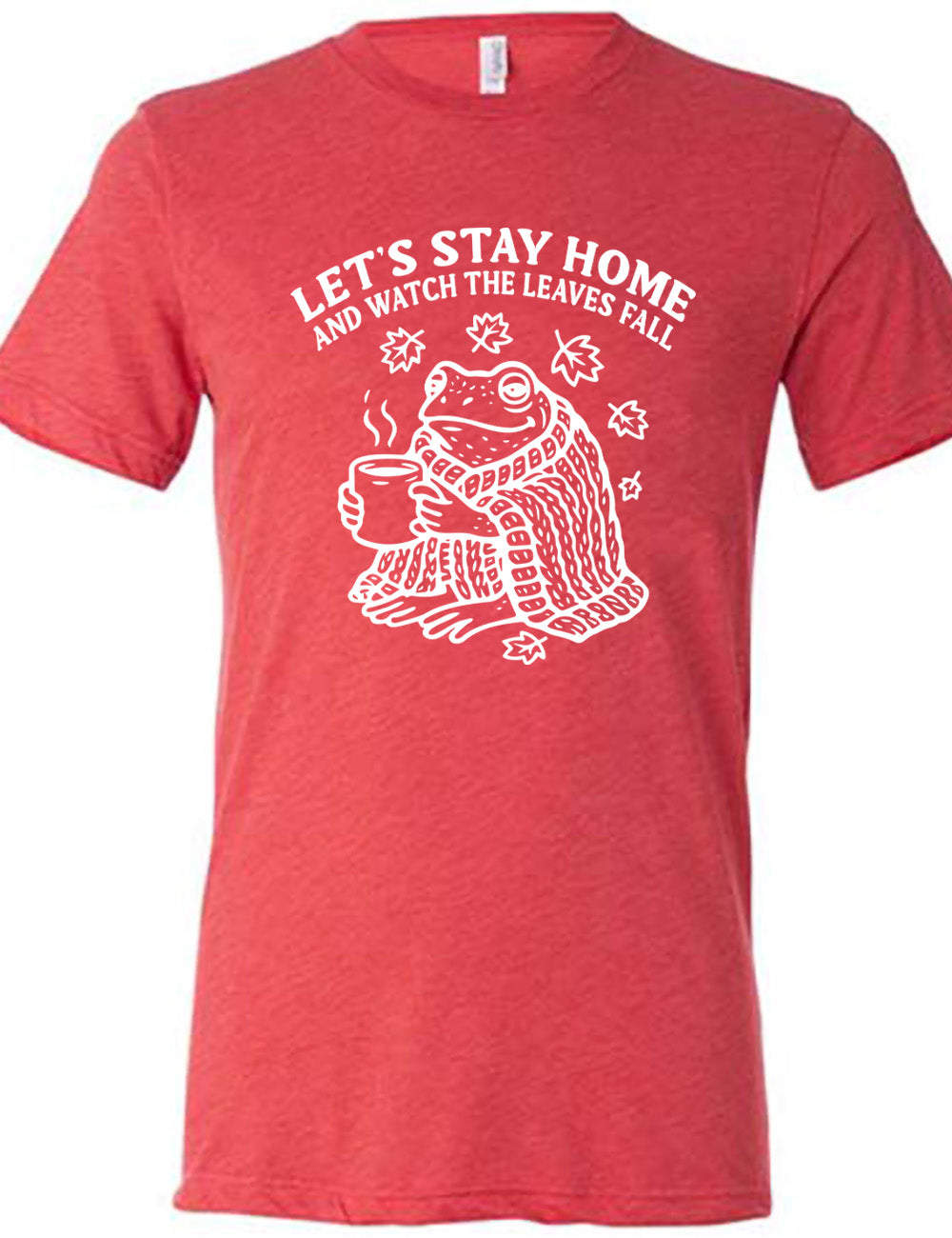 red unisex tee with the words "let's stay home and watch the leaves fall" on it, and the graphic underneath of a frog, wrapped in a blanket, holding a mug of steaming beverage, with five leaves arching over it