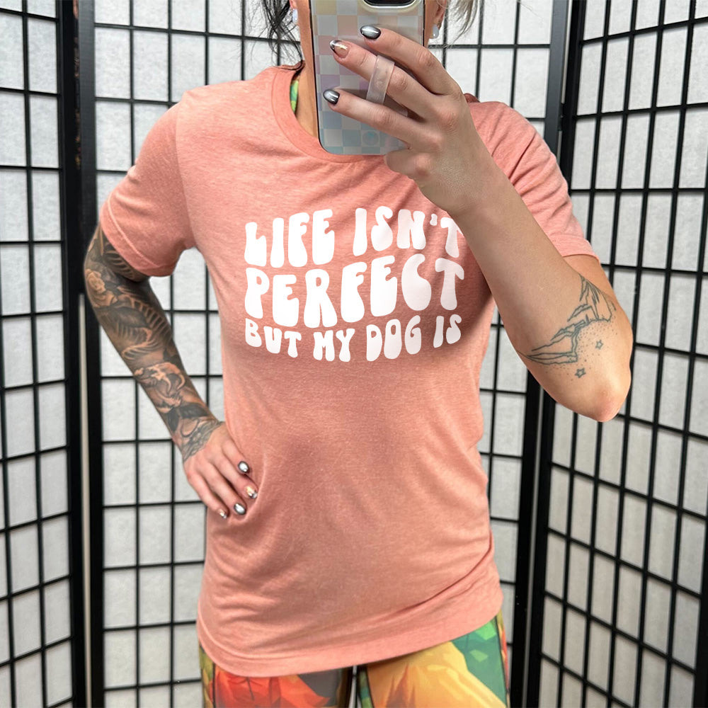 Model wearing sunset colored shirt with graphic on it that says "Life Isn't Perfect But My Dog Is"