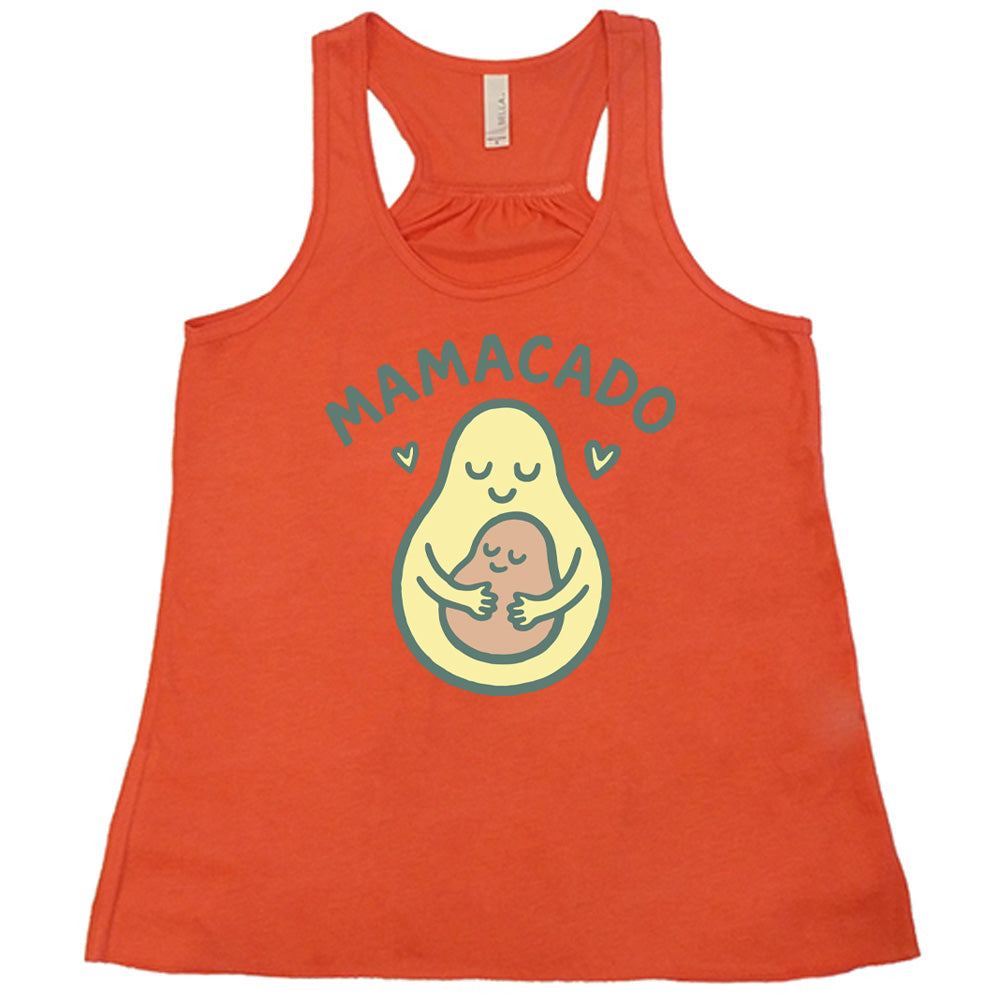 coral racerback flowy tank with the words "mamacado" on it, with the graphic of an avocado, peacefully smiling, with arms, holding her smiling baby (the color and placement of the avocado pit - but in the shape of an avocado), with a little heart on either side