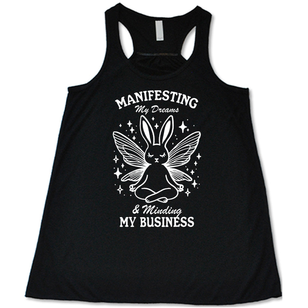 Black flowy tank with the words "Manifesting My Dreams & Minding My Business" and the graphic of a meditating rabbit with butterfly wings