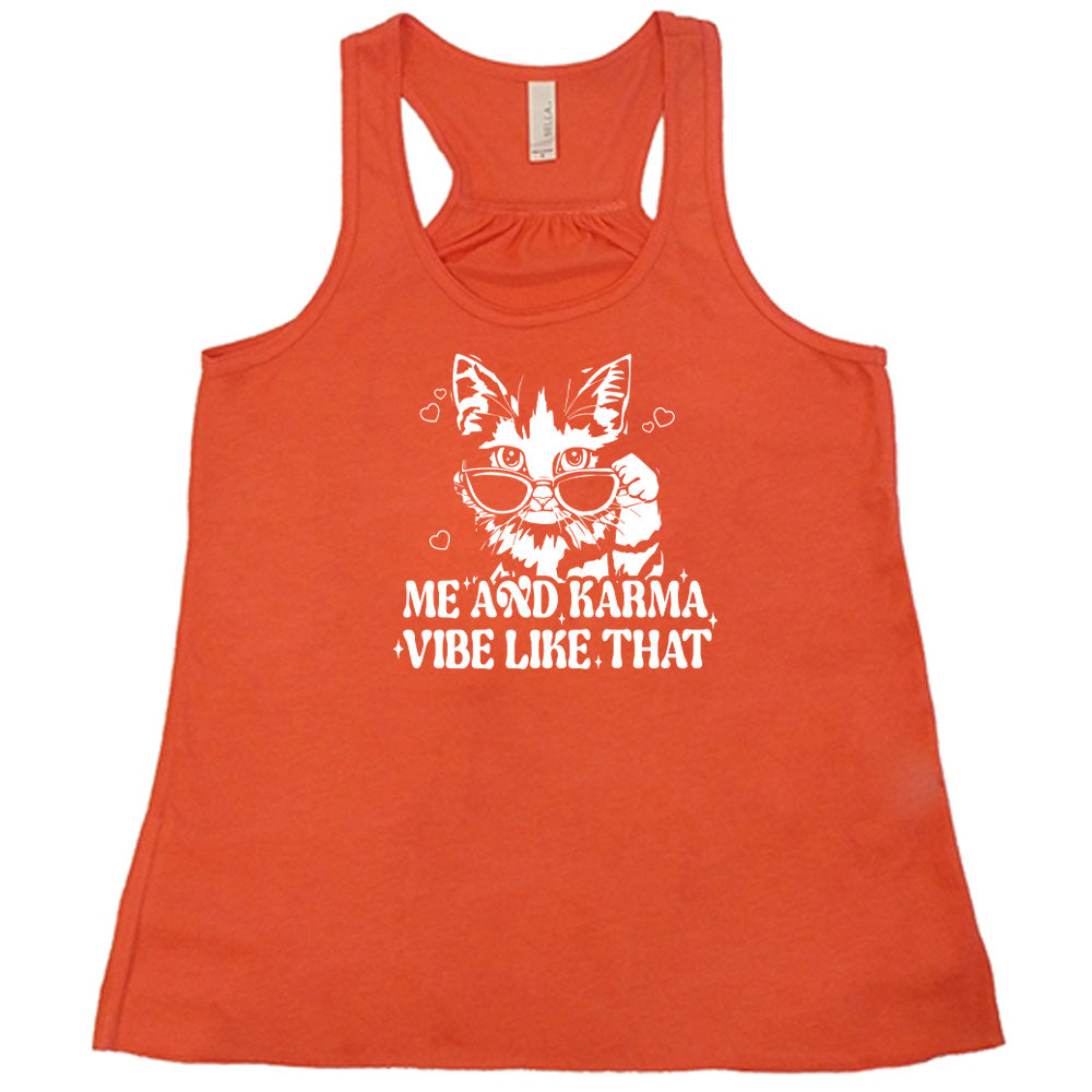Coral colored flowy tank with a cat wearing sunglasses graphic on it that says "Me and Karma Vibe Like That"