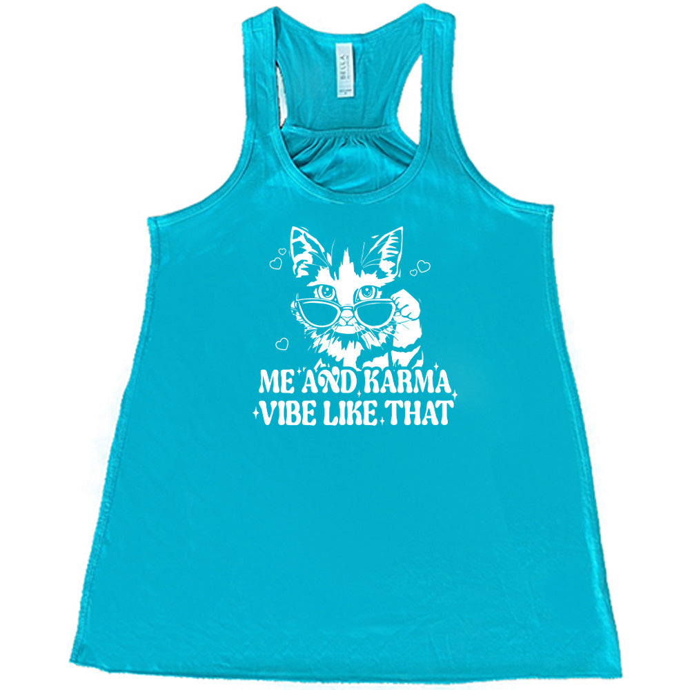 Teal colored flowy tank with a cat wearing sunglasses graphic on it that says "Me and Karma Vibe Like That"