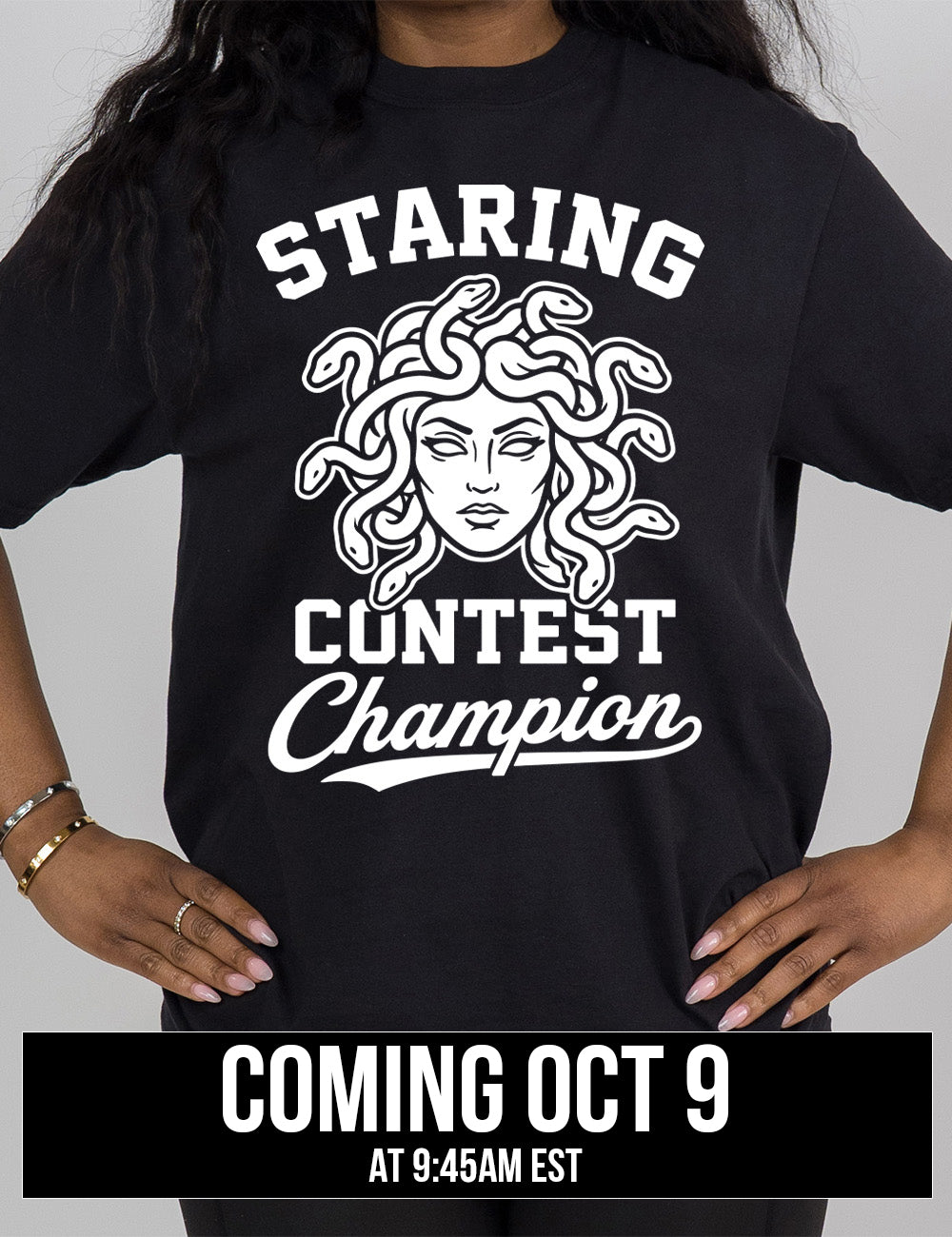 black modern tee with words surrounding the graphic of medusa's head saying "staring contest champion" Coming October 9th