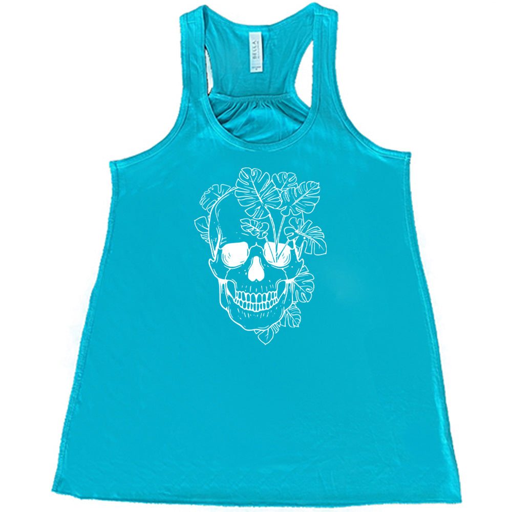 Teal colored flowy tank with a monstera plant and skull graphic on it