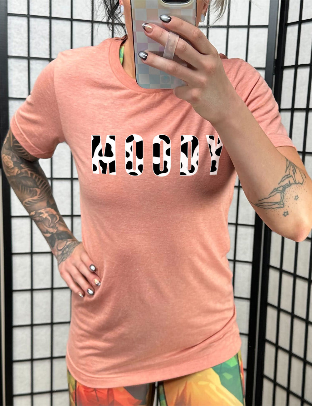 sunset unisex tee with the word "moody" in all caps on it, with the font being cow print