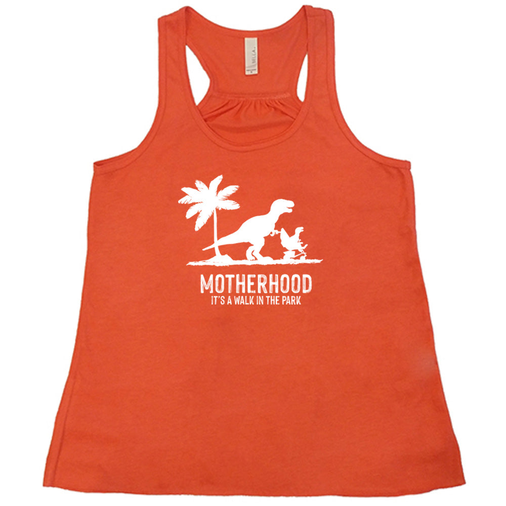 Coral colored flowy tank with a mother and child dinosaur graphic on it that says "Motherhood, Its a Walk in the Park"