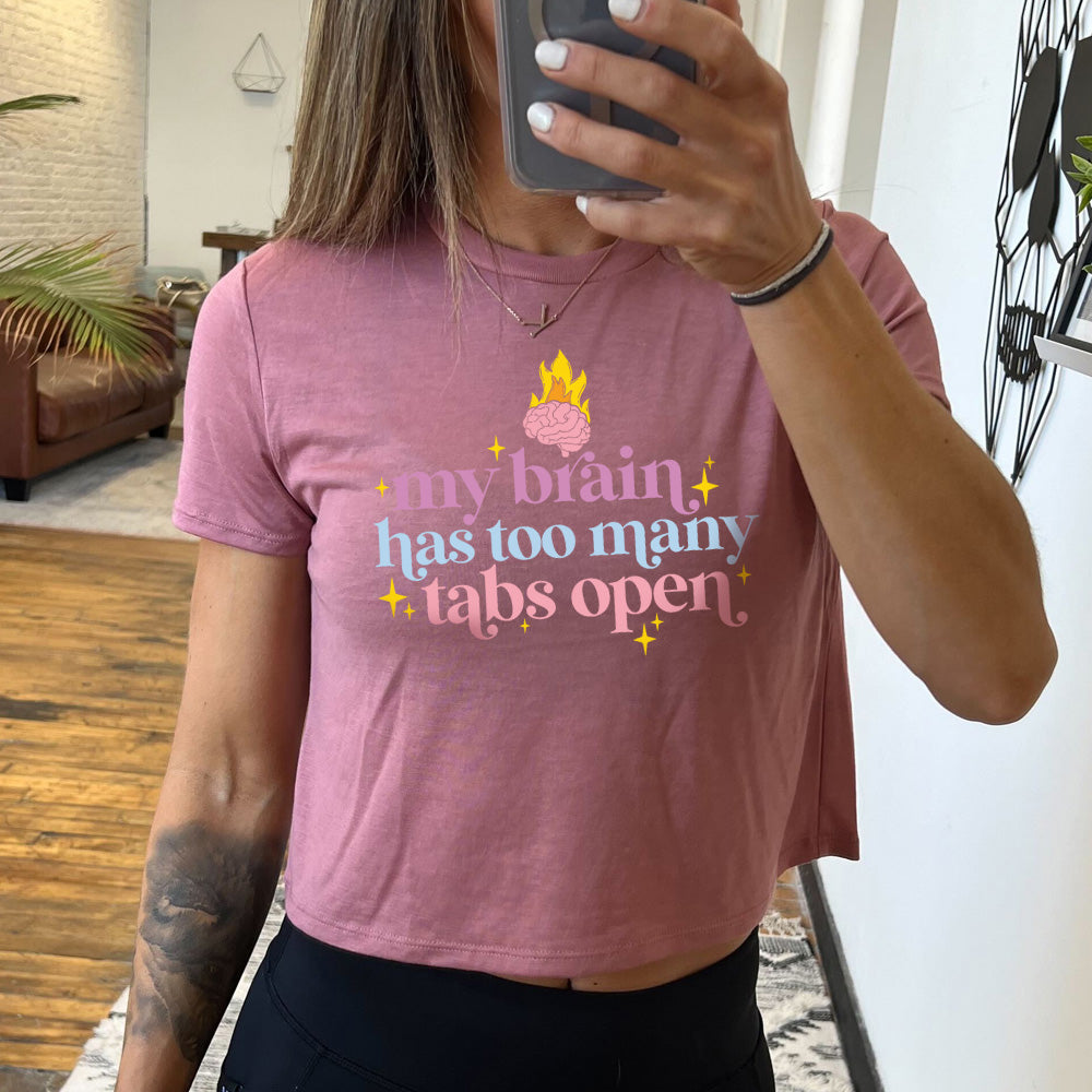 mauve cropped tee with a flaming brain graphic on it that says "My Brain Has Too Many Tabs Open"