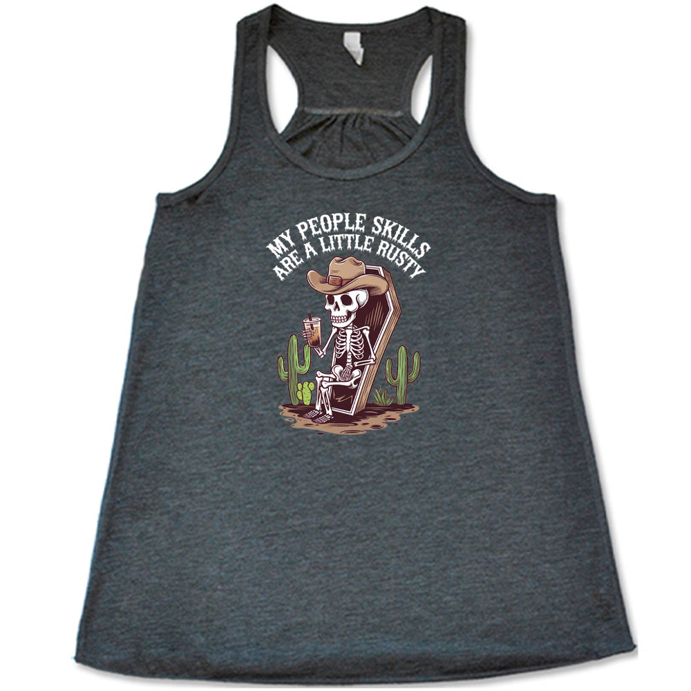 Grey colored flowy tank with a skeleton sitting in a coffin graphic on it that says "My People Skills Are A Little Rusty"