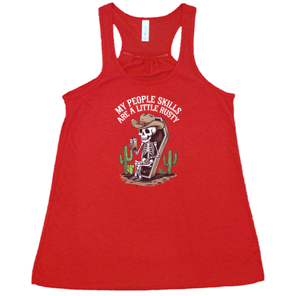 Red colored flowy tank with a skeleton sitting in a coffin graphic on it that says "My People Skills Are A Little Rusty"