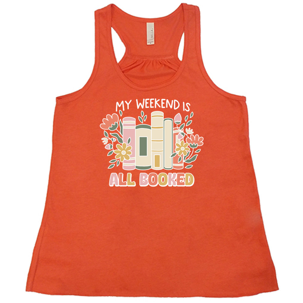 Coral colored flowy tank with books and flowers graphic on it that says "My Weekend Is All Booked"