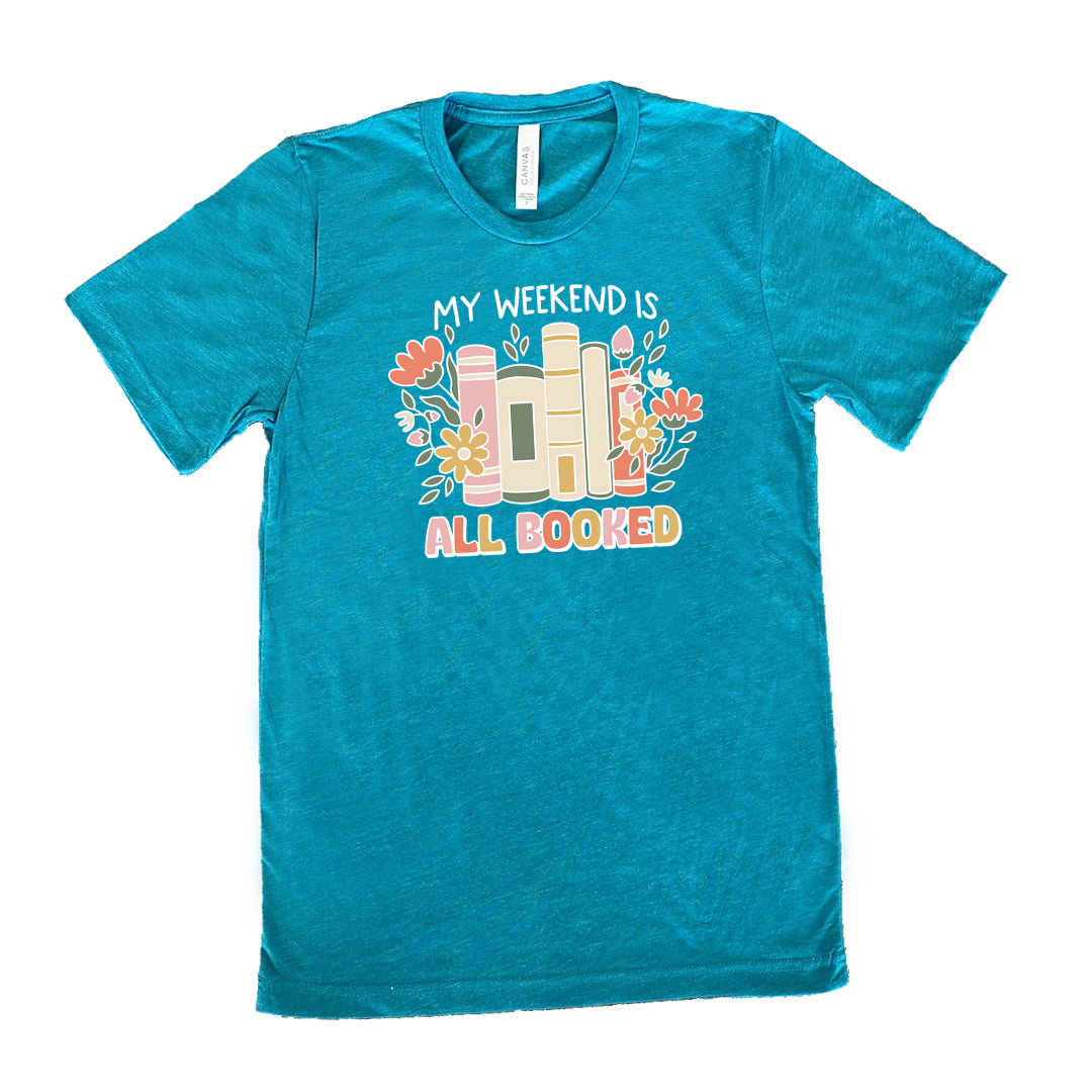 Teal colored shirt with books and flowers graphic on it that says "My Weekend Is All Booked"
