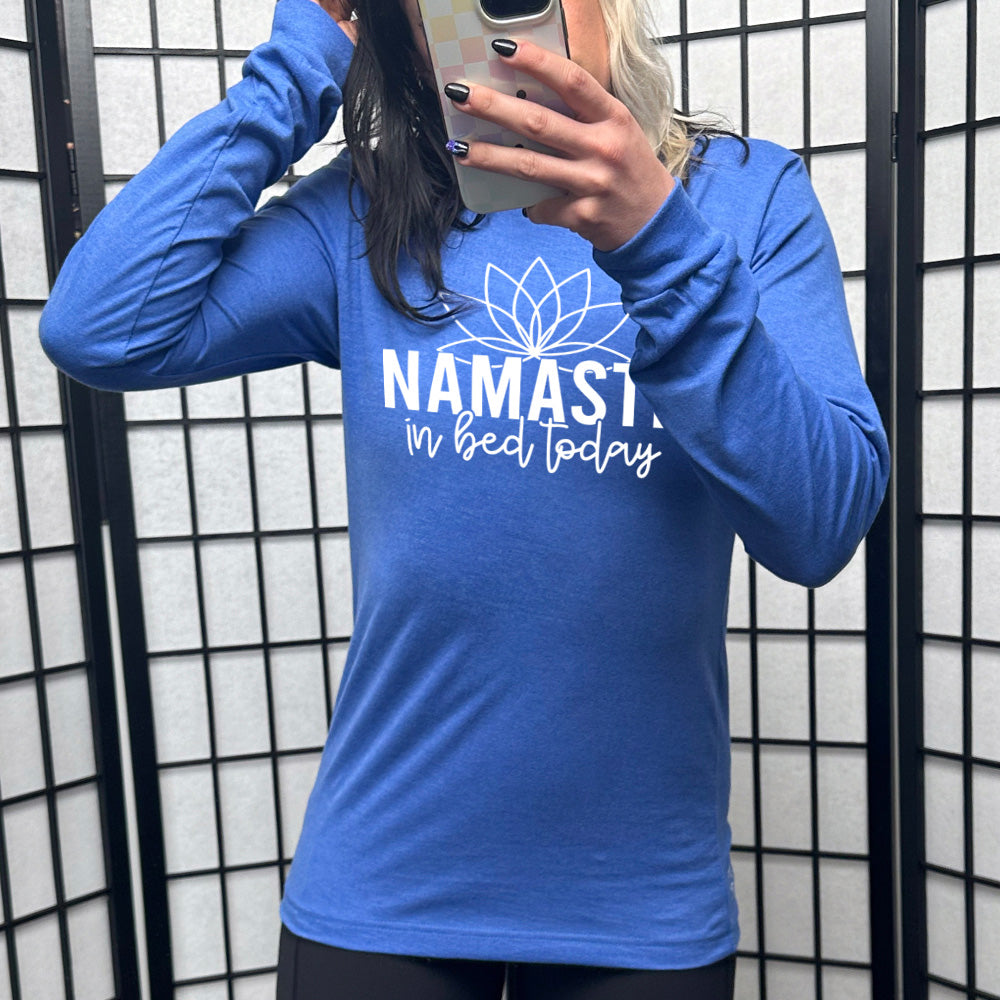 Heather true royal blue long sleeve shirt with the words "Namaste in bed today" with a line art of a lotus flower above it