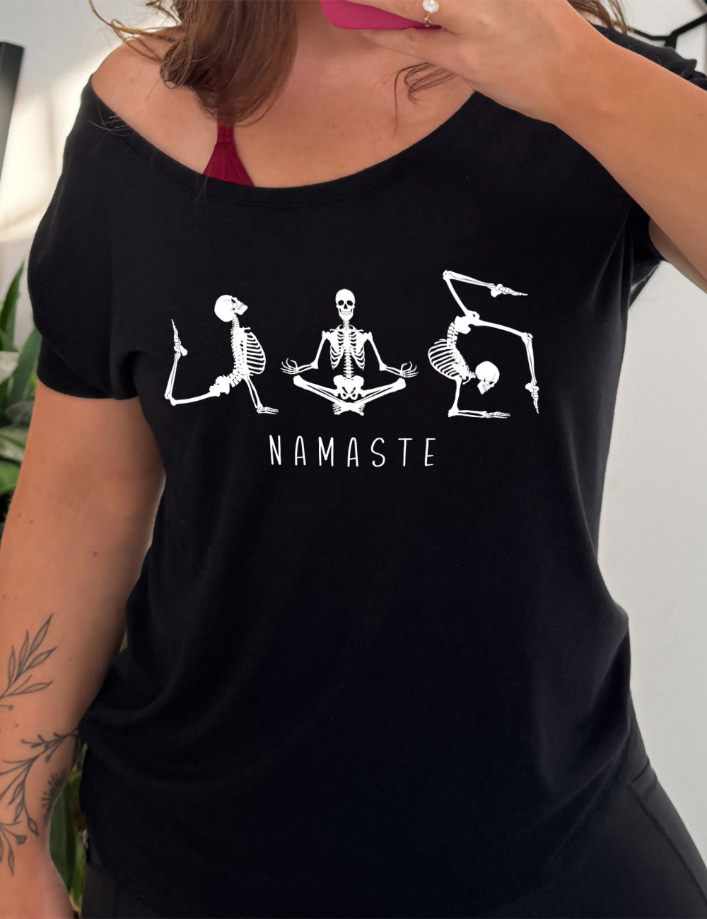 black slouchy tee with the graphic of three skeletons, all doing yoga poses, and the word underneath saying "namaste"