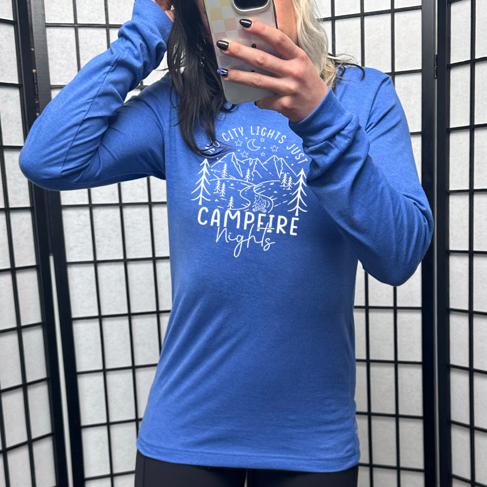 Heather true royal long sleeve shirt with a stars and mountain graphic on it that says "No City Lights Just Campfire Nights"