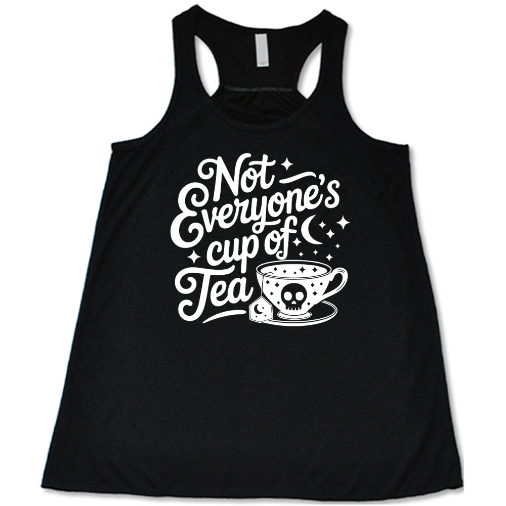 black flowy tank with the words "not everyone's cup of a tea" in a cursive font, with the graphics of a moon and little stars, and a tea cup with a skull on it with stars and the tea bag has a moon on it