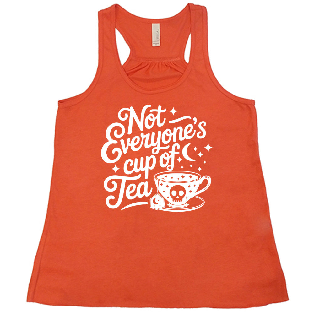 coral flowy tank with the words "not everyone's cup of a tea" in a cursive font, with the graphics of a moon and little stars, and a tea cup with a skull on it with stars and the tea bag has a moon on it