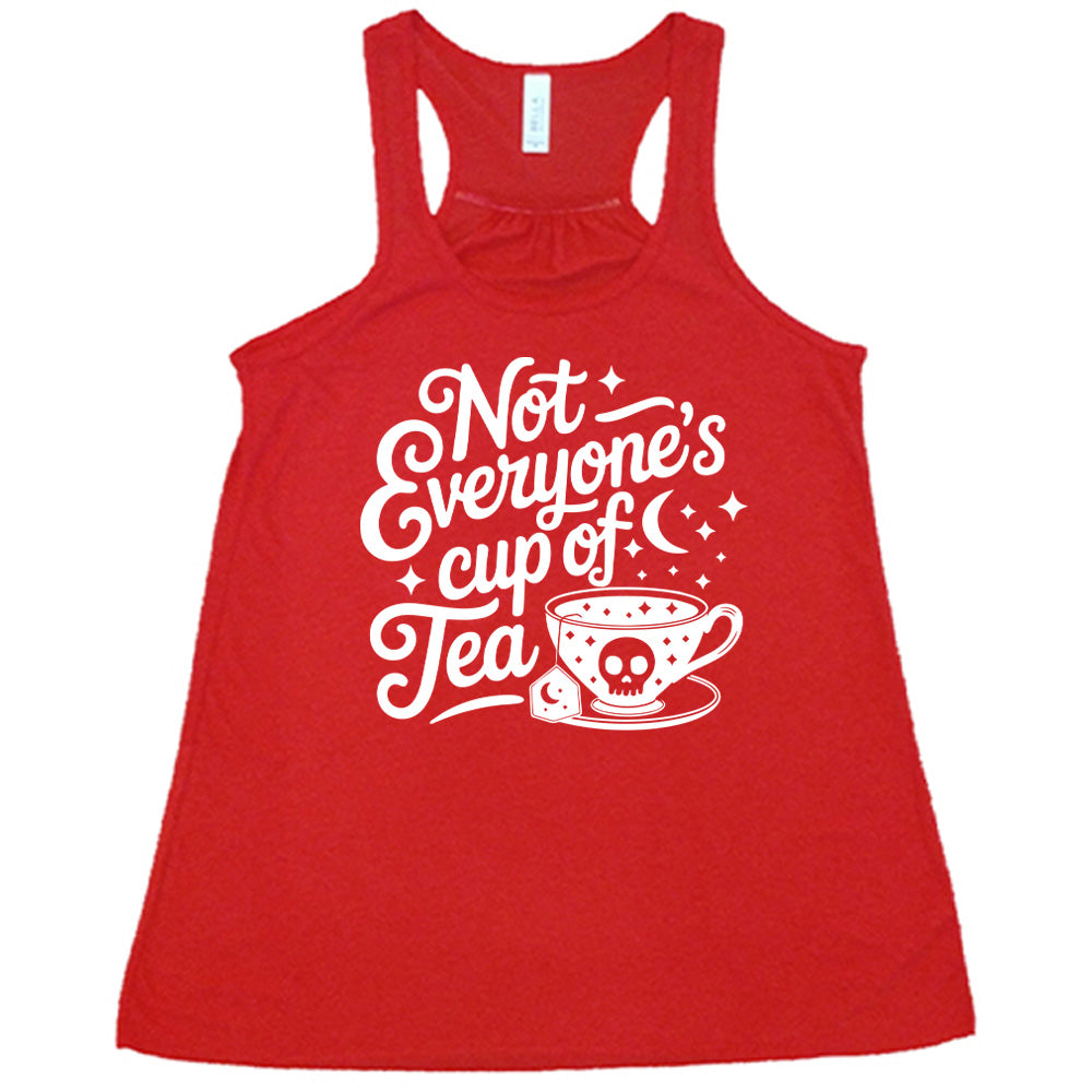red flowy tank with the words "not everyone's cup of a tea" in a cursive font, with the graphics of a moon and little stars, and a tea cup with a skull on it with stars and the tea bag has a moon on it