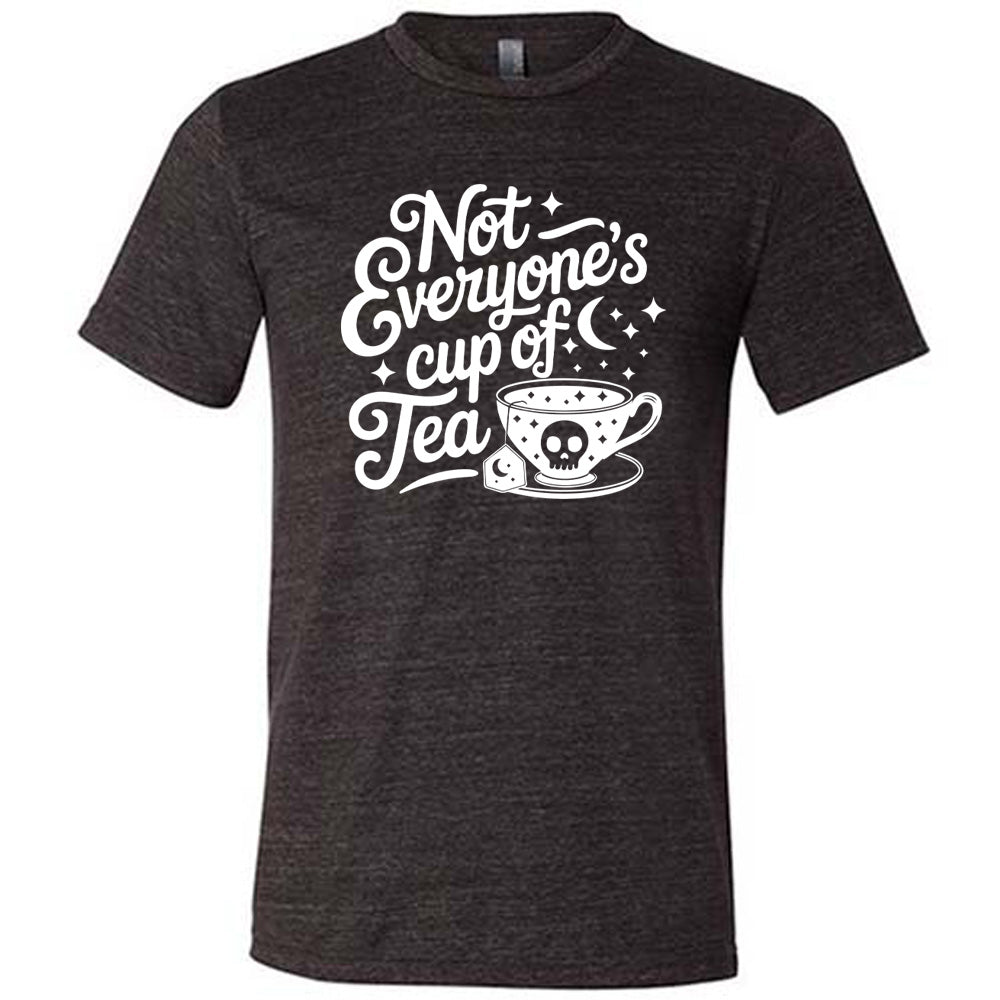 black unisex tee with the words "not everyone's cup of a tea" in a cursive font, with the graphics of a moon and little stars, and a tea cup with a skull on it with stars and the tea bag has a moon on it