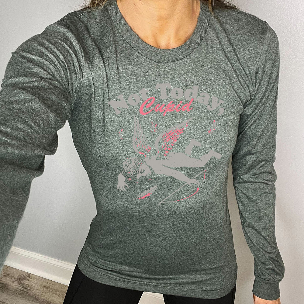 heather forest long sleeve shirt with the words "not today, Cupid" on it, with the graphic of cupid, presumably dead, lying on the ground, bow at his side, with an arrow through his back