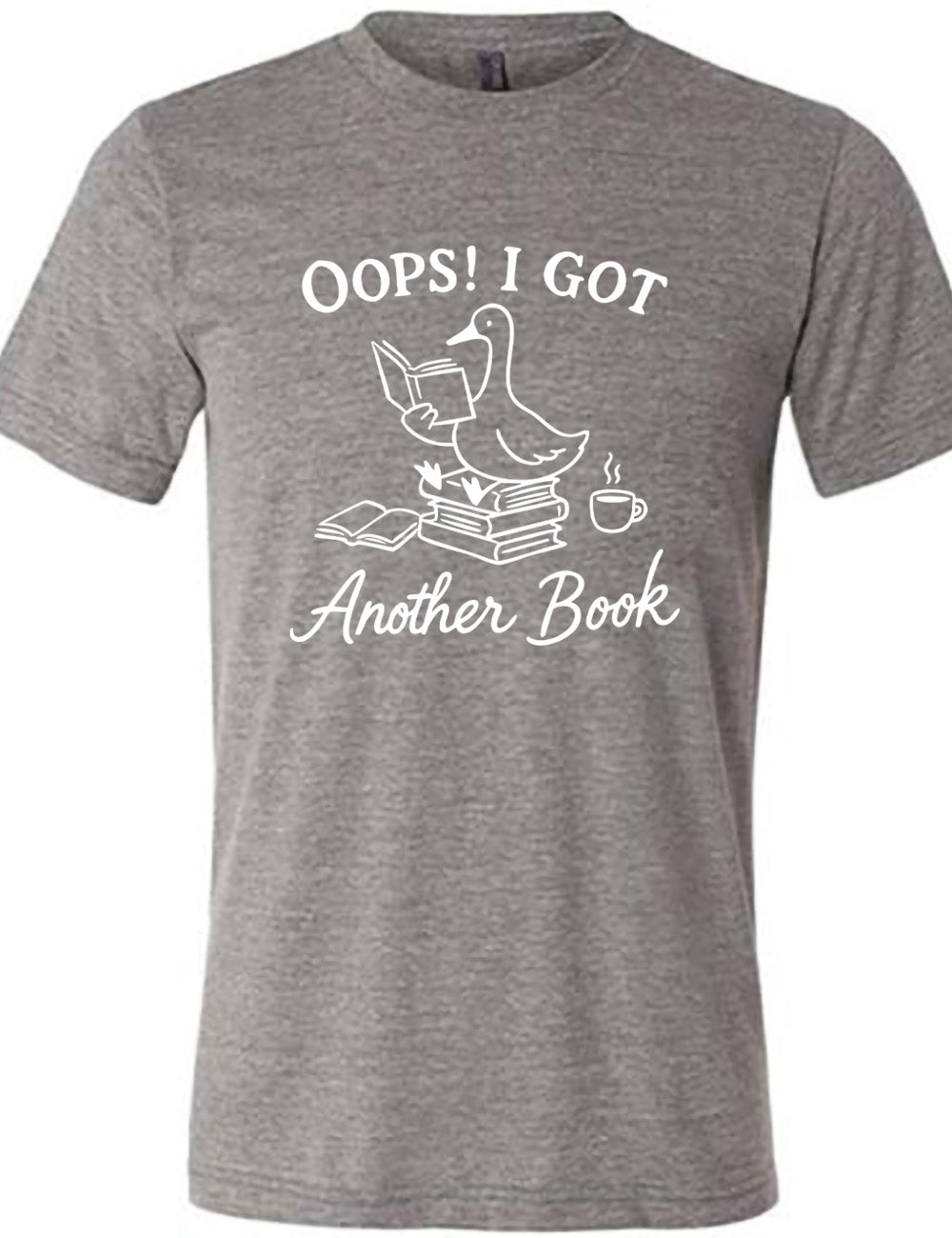 grey unisex tee with the graphic of a goose, sitting on a stack of books, reading a book, with another book open beside the stack, and a steaming cup of coffee on the other side, with the words around the graphic saying "Oops! I got another book"